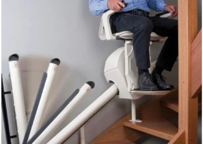 Elderly gentleman smiling while using a stairlift in a Gloucester home
