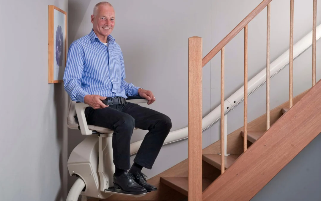 Hands On Stairlifts curved stairlift in use with man at bottom of stairs