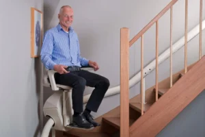 Hands On Stairlifts curved stairlift in use with man at bottom of stairs
