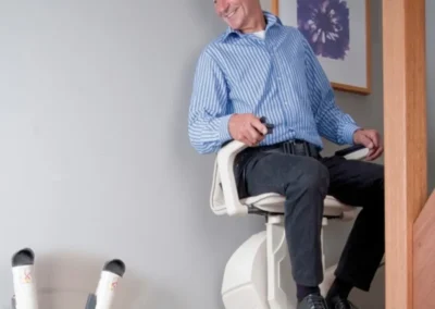 Hands On Stairlifts installation with man using curved stairlift in South Wales