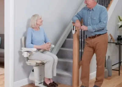 Couple smiling at bottom of straight stairlift in a South West home