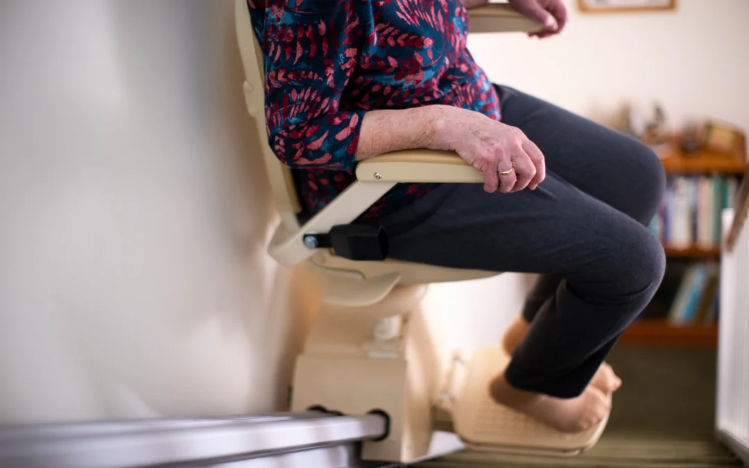 Detail Of Senior Woman Sitting On Stair Lift At Home To Help Mobility