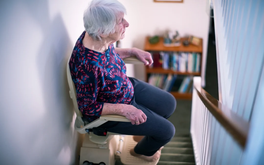 Elderly lady using curved stairlift in Bath home
