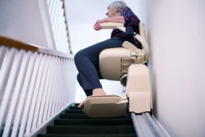 Lady using stairlift in Bristol home for better access to upstairs